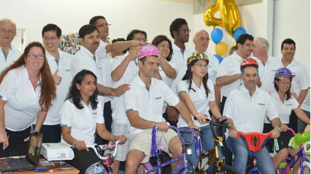 Novatek employee teams assembling donated bicycles for a concussion-assessment charity